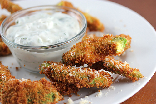 Crispy avocado fries served with ranch dipping sauce on a white plate