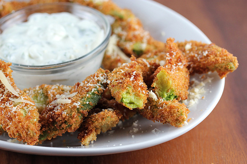 Crispy avocado fries served with ranch dipping sauce on a white plate