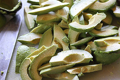 Fresh avocado slices on a cutting board ready for breading