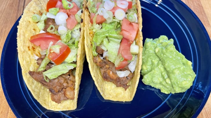 Prepared baked tacos on plate with guacamole.