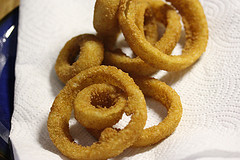 Golden fried onion rings on a paper towel