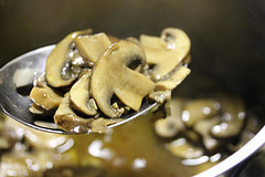 Sautéed mushrooms in broth on a spoon