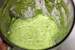 Blender cup filled with creamy avocado dressing mixture