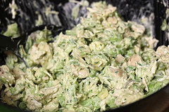 Bowl of avocado chicken salad being mixed together with diced chicken and avocado