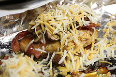 Chicken breast topped with melted cheese, bacon, and mushrooms in a skillet