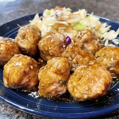 Hoisin meatballs on plate with Asian slaw.