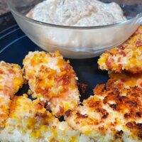 Close up view of cheddar bacon chicken tenders, served with ranch sauce.