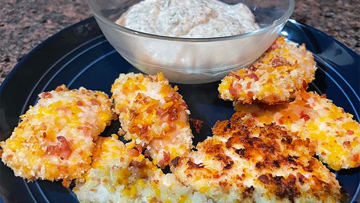 Close up view of cheddar bacon chicken tenders, served with ranch sauce.