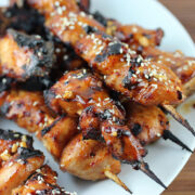 Grilled Chinese chicken skewers topped with sesame seeds