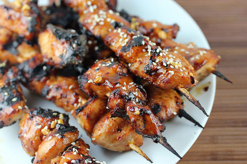 Grilled Chinese chicken skewers topped with sesame seeds