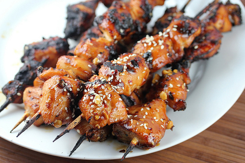 Grilled Chinese chicken skewers topped with sesame seeds