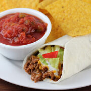 Burrito supreme served with salsa and tortilla chips on the side