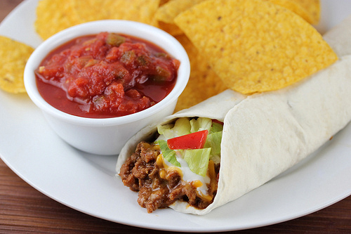 Burrito supreme served with salsa and tortilla chips on the side