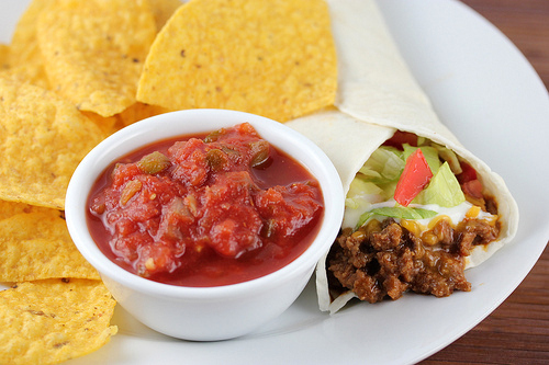 Burrito supreme served with salsa and tortilla chips on the side