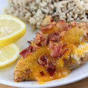 Plate with baked chicken breast served with lemon slices and rice