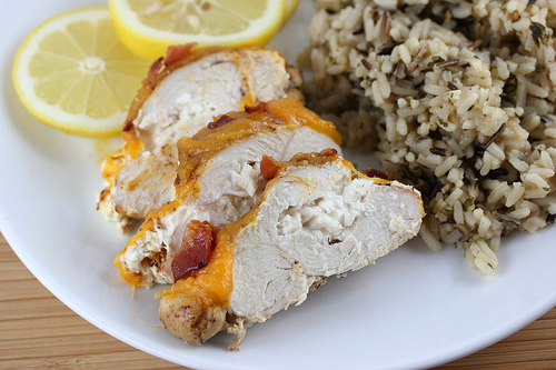 Sliced chicken breast plated with rice and lemon slices