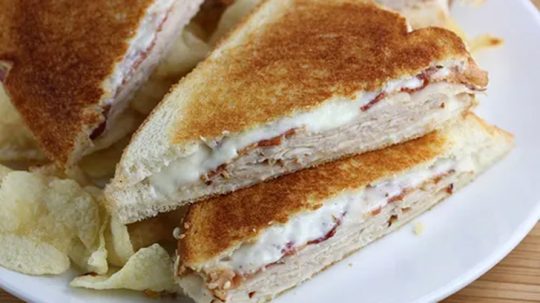 Close up of turkey grilled cheese sandwich with bacon.