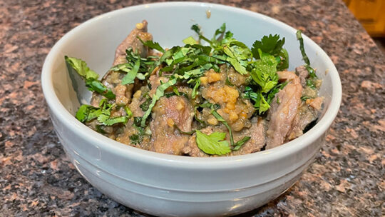 Close up view of Chinese beef with peanuts in a dish.