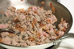 Sausage being cooked in a skillet for breakfast casserole preparation