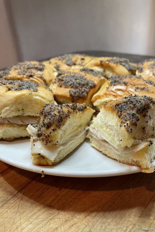 Turkey and cheese sliders with poppy seed sauce.