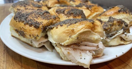 Turkey and cheese sliders with poppy seed sauce.