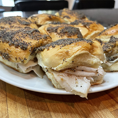 Turkey and cheese sliders with poppy seed sauce.