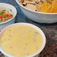 Close up view of Applebees queso dip with pico de gallo and chips.
