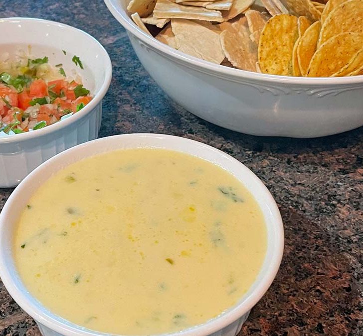 Close up view of Applebees queso dip with pico de gallo and chips.