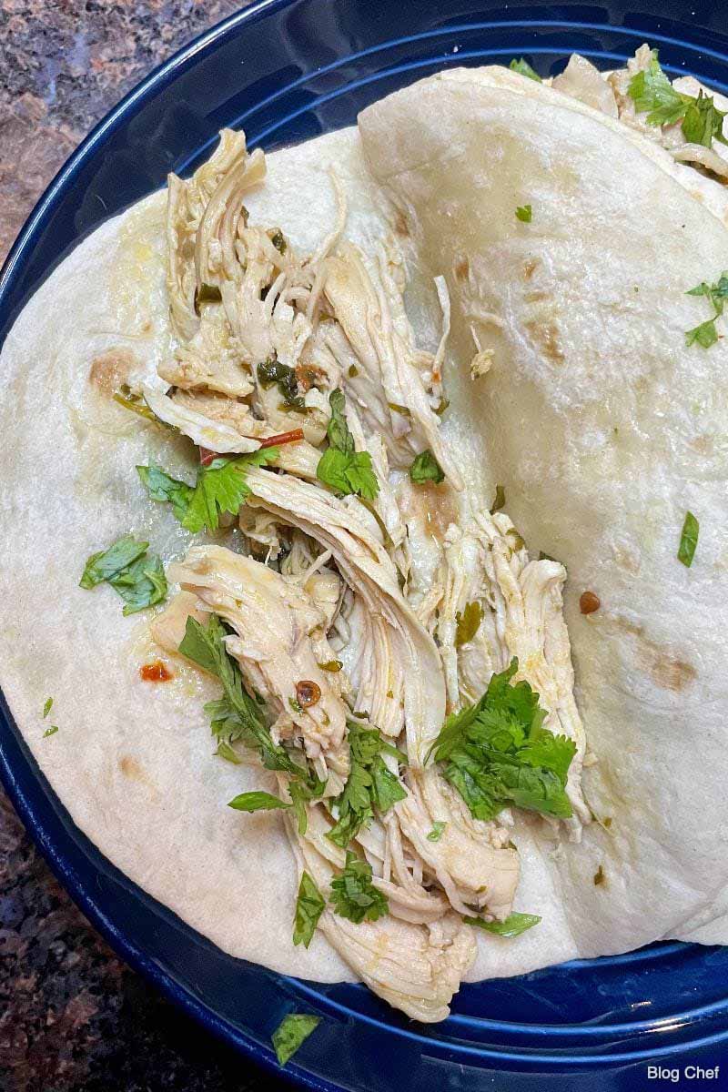 Prepared chicken tacos on soft flour tortillas.