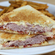 tacked grilled ham and gouda cheese sandwich halves with melted cheese, served with fries
