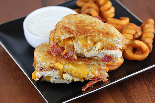 Chicken bacon ranch grilled cheese sandwich served with curly fries and ranch dressing