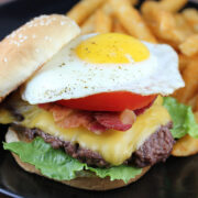 Close-up of Royal Red Robin Burger topped with a fried egg, served with fries
