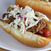 Hot dog with shredded pork, coleslaw, and pickle inside a bun