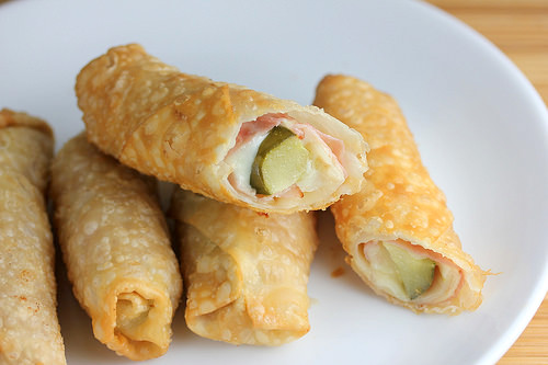 Plate of fried pickle egg rolls with ham filling