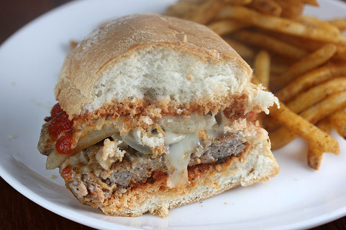 cudighi sausage sandwich with mozzarella, marinara sauce, mushrooms and onions on a toasted roll
