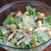 Here’s a concise and SEO-friendly alt tag with no period that works for both images: **Homemade caesar salad with croutons parmesan and grilled chicken in a glass bowl