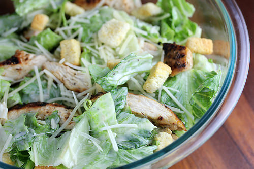Here’s a concise and SEO-friendly alt tag with no period that works for both images: **Homemade caesar salad with croutons parmesan and grilled chicken in a glass bowl