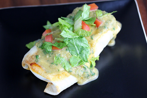 Chi Chis chimichanga topped with lettuce tomato and green sauce