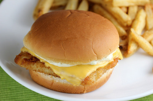 Filet o Fish sandwich with cheese and tartar sauce on a soft bun served with fries