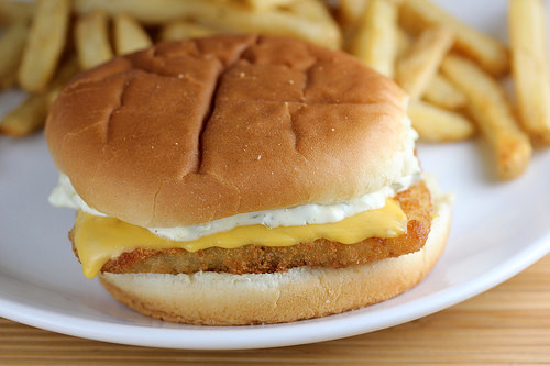Filet o Fish sandwich with cheese and tartar sauce on a soft bun served with fries
