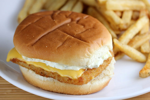 Filet o Fish sandwich with cheese and tartar sauce on a soft bun served with fries