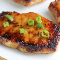 Prepared baked pork chops on white plate.