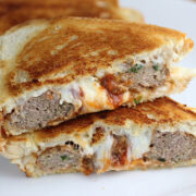 Meatball grilled cheese sandwich cut in half on a white plate
