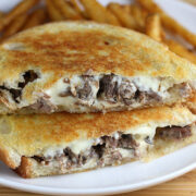 Short rib grilled cheese sandwich with melted cheese served with fries