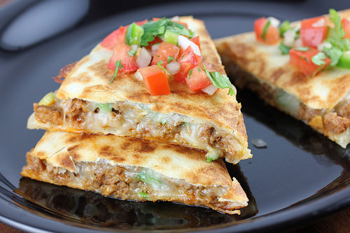 Chorizo quesadillas served on a black plate