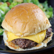 Garlic steakburger with melted cheese on a toasted bun served with a side salad