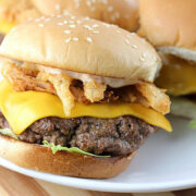 Bloomin burger with cheddar cheese lettuce and crispy onion petals on a sesame bun