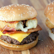 Mozzarella stick cheeseburger with bacon and beef patty on wooden surface