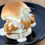 Fried chicken slider with gravy on plate.