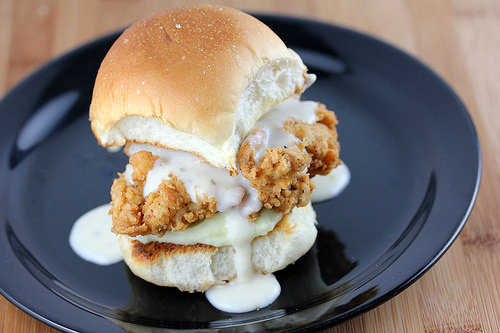 Fried chicken slider with gravy on plate.